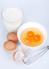 Eggs, cup of milk and whisk