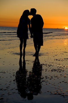 A couple kissing at sunset on the beach