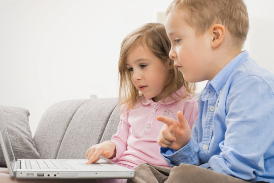 Little brother and sister with laptop