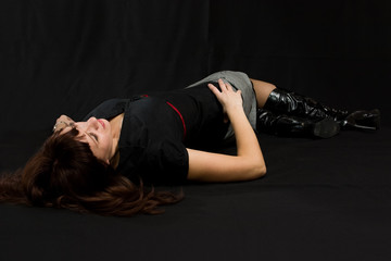 Young sexy woman lie on black.