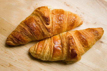 Two croissants on wooden table