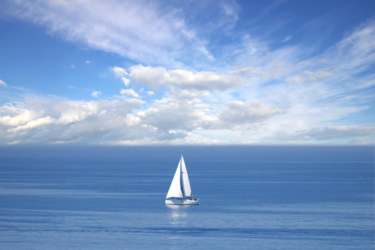 Lonely white sail at infinite ocean