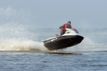 Fototapeta premium Jet ski in action with water spray on the blue sea