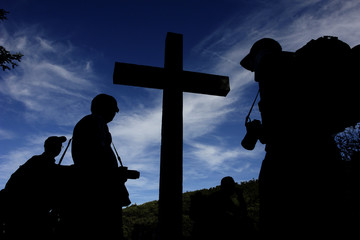 silhouette of a cross, with people in return of it...