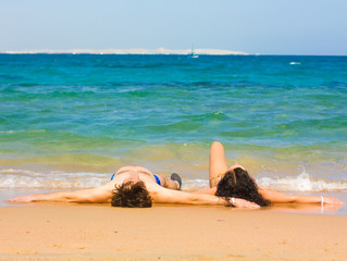 Loving couple lying down by a sea