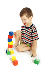 The little boy plays with cubes