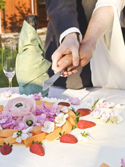 Obraz na płótnie Canvas Just married couple is slicing their wedding cake