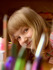 Smiling little girl with pen&ntilde;ils and brushes.