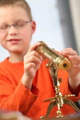 Boy is looking through a classic telescope.