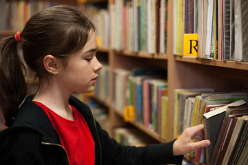 Young girl in library looking for books