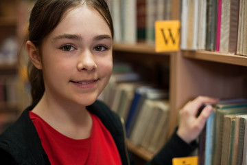 Young girl in library looking for books