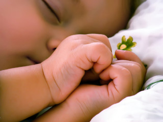 The kid sleeps, handles a heart.