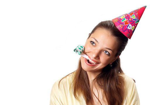 Young pretty woman in birthday cap with noisemaker