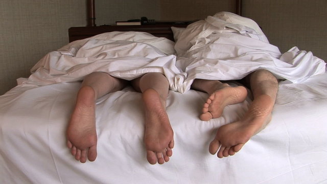 Feet of Couple in Bed