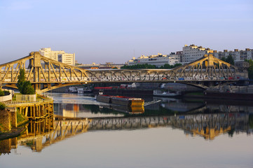 Fototapeta premium péniche sur la seine sous pont à l'entrée de paris