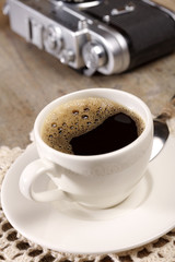 espresso coffee and old retro camera on background
