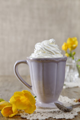 morning coffee with whipped cream and fresia yellow flowers