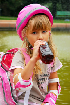 young girl drinking and  rollerskating