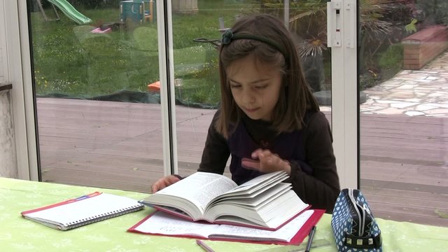 fillette cherchant dans le dictionnaire