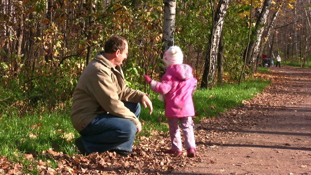 little girl run to senior in autumn park