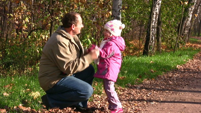 senior with little girl in autumn park with mitten