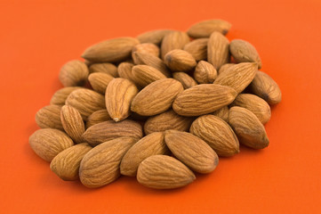 Almonds, orange background.