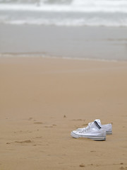 Fototapeta na wymiar Zapatillas de deporte en la playa
