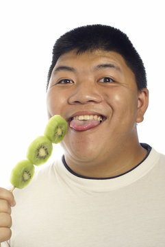 Happy Asian Man Eating Green Kiwi Fruit