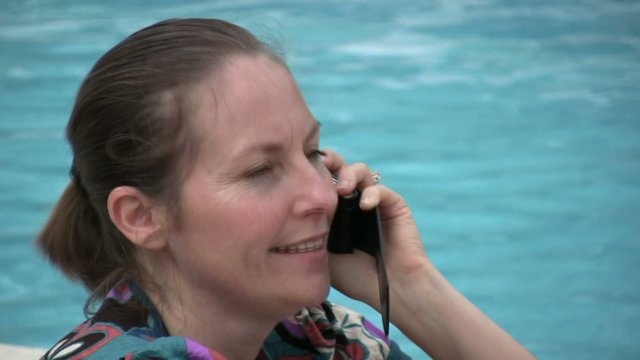 femme au t&eacute;l&eacute;phone au bord de la piscine
