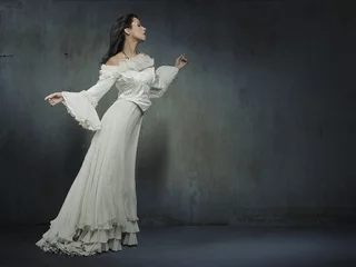 Fototapete Rund Beautiful woman wearing white dress over a grungy wall © konradbak