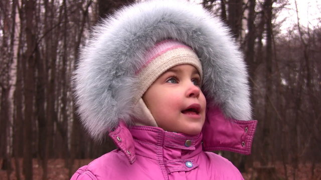 little girl with fur hood in park