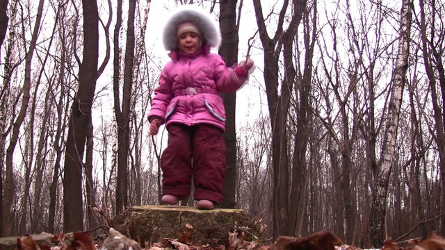 little girl jump from stub in winter park