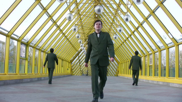 marching businessmen clones on bridge