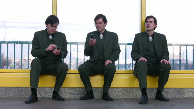 three businessmen clones sit near window