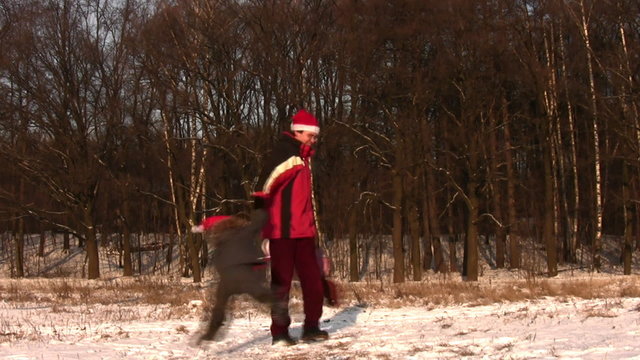 father rotating children in christmas hats