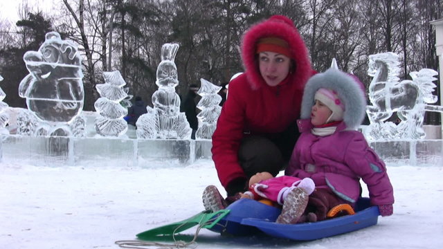 Mother with small girl on background of icy figures