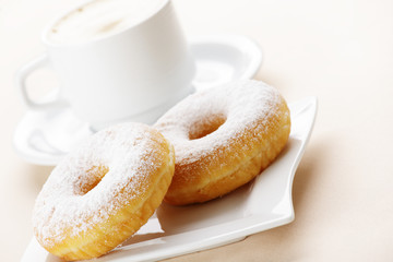 Two donuts with cup of coffee