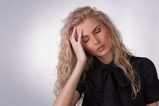 Young woman in black blouse having a headache