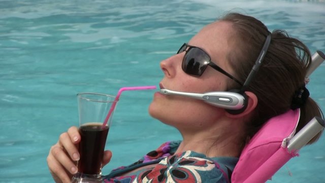 femme buvant et t&eacute;l&eacute;phonant au bord de la piscine 2
