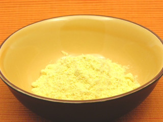 Maismehl in einer Keramikschale auf orangem Hintergrund