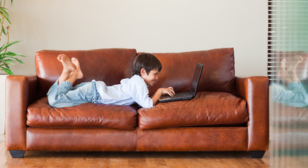 Obraz premium Young kid playing with a laptop