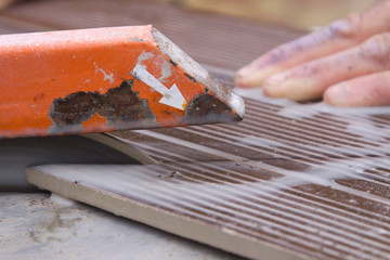 tile-layer who poses tiling on a terrace