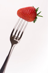red strawberry on fork