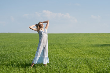 Fototapeta premium Young woman in nightdress on green meadow