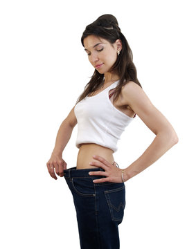 Slim lady in white T-shirt trying on jeans after diet