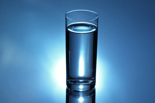 glass with water on blue