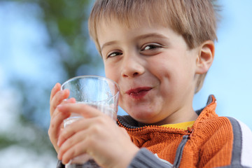 lachender Junge mit Wasserglas