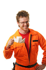 worker in workwear holds the toy-ship built from a paper