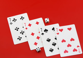 The dice and playing cards on red background.