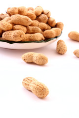 Few peanuts and dish isolated on white